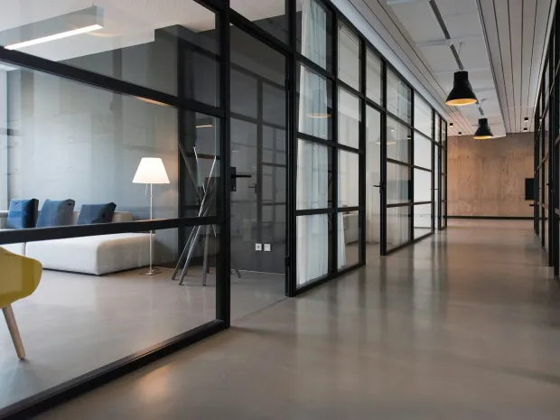 A finished office with glass-walled rooms off a hallway