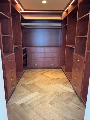 Walk-in closet in dark wood over a herringbone floor, by DreamPro Contracting