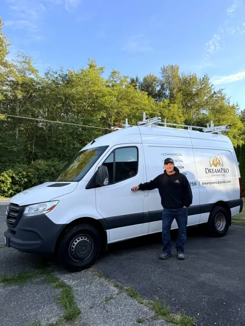 David, owner of DreamPro Contracting, standing with the company van