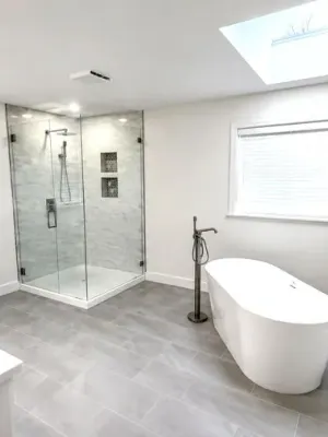 Bathroom with a walk-in glass shower, a freestanding tub, and a skylight in South Surrey, by DreamPro Contracting