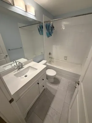 Bathroom rebuilt after water damage, with a new vanity and large-format floor tile, in White Rock, by DreamPro Contracting