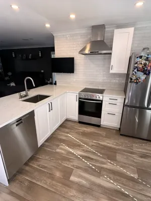 Refaced kitchen with extended quartz counters, a tile backsplash, and an undermount sink in South Surrey, by DreamPro Contracting