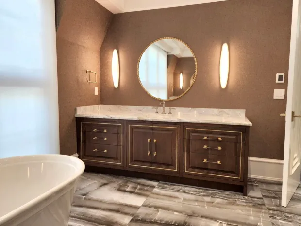 Finished ensuite with a walnut double vanity, a marble counter, and a freestanding tub, built by DreamPro Contracting