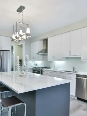Finished kitchen with white shaker cabinetry and a waterfall quartz island in White Rock, by DreamPro Contracting