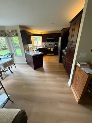 Kitchen with dark cabinetry, an island, and new wide-plank flooring in South Surrey, by DreamPro Contracting